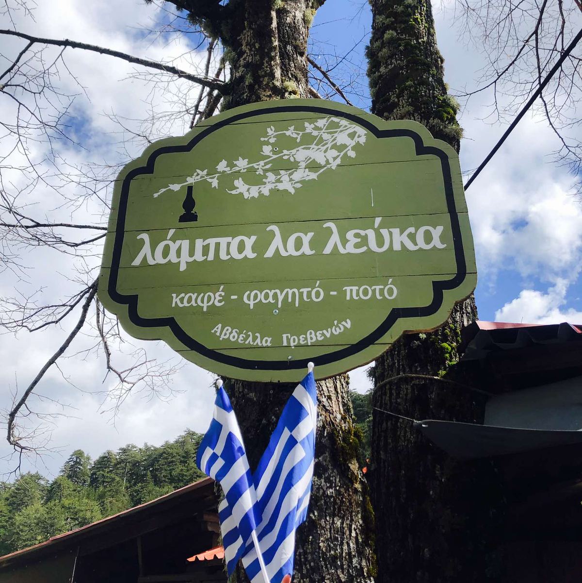 Η πινακίδα Λάμπα λα λεύκα στο δέντρο, με ελληνικές σημαίες